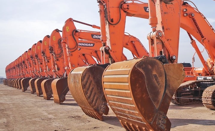 Image depicts a row of new excavators lined up ready for plant capital expenditure utilising super deductions